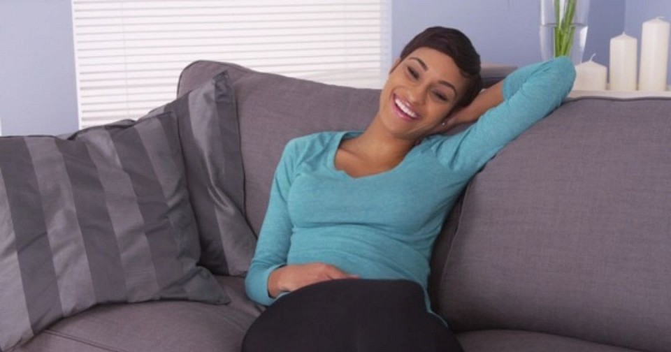 A woman yogini is relexing on sofa after her daily yoga practice in Studio.